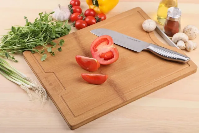 tabla de corte con cuchillo de alta gama y tomate cortado