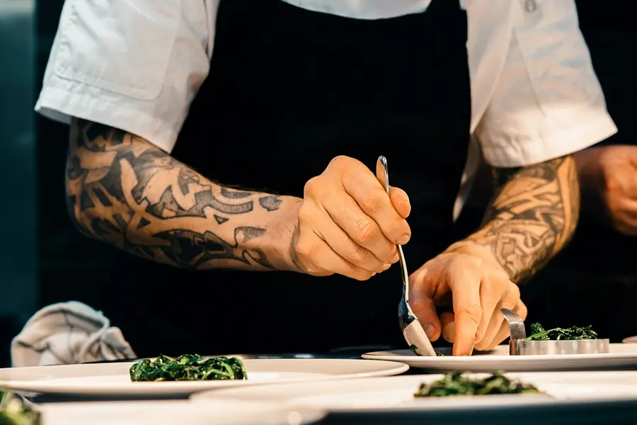Cocinero instituto de gastronomía enseñando como decorar platos