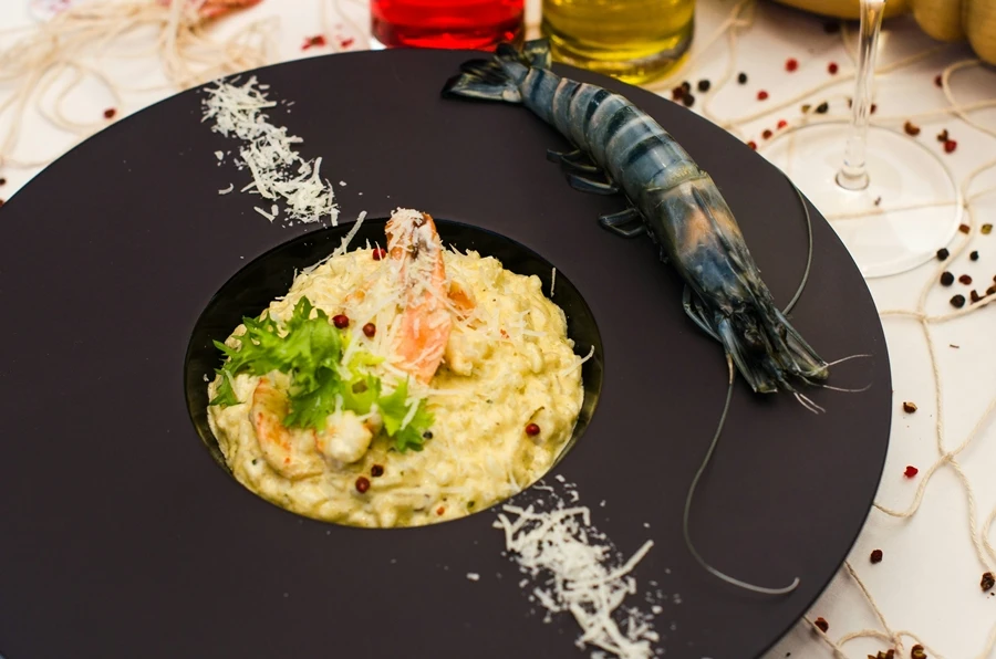 plato negro con una porción de risotto italiano