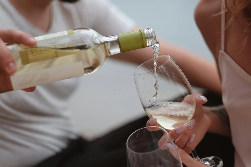 Una botella de vino blanco personas, una botella de vino blanco y copas de vico
